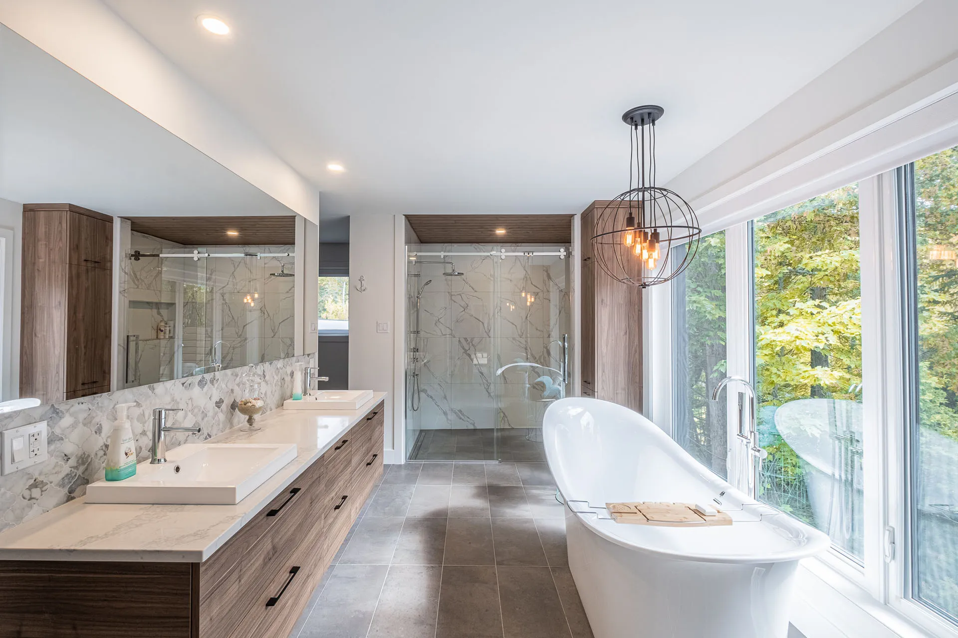 Simard bathroom: walnut cabinets, white marble countertops, freestanding tub, glass shower, double vanity, pendant light