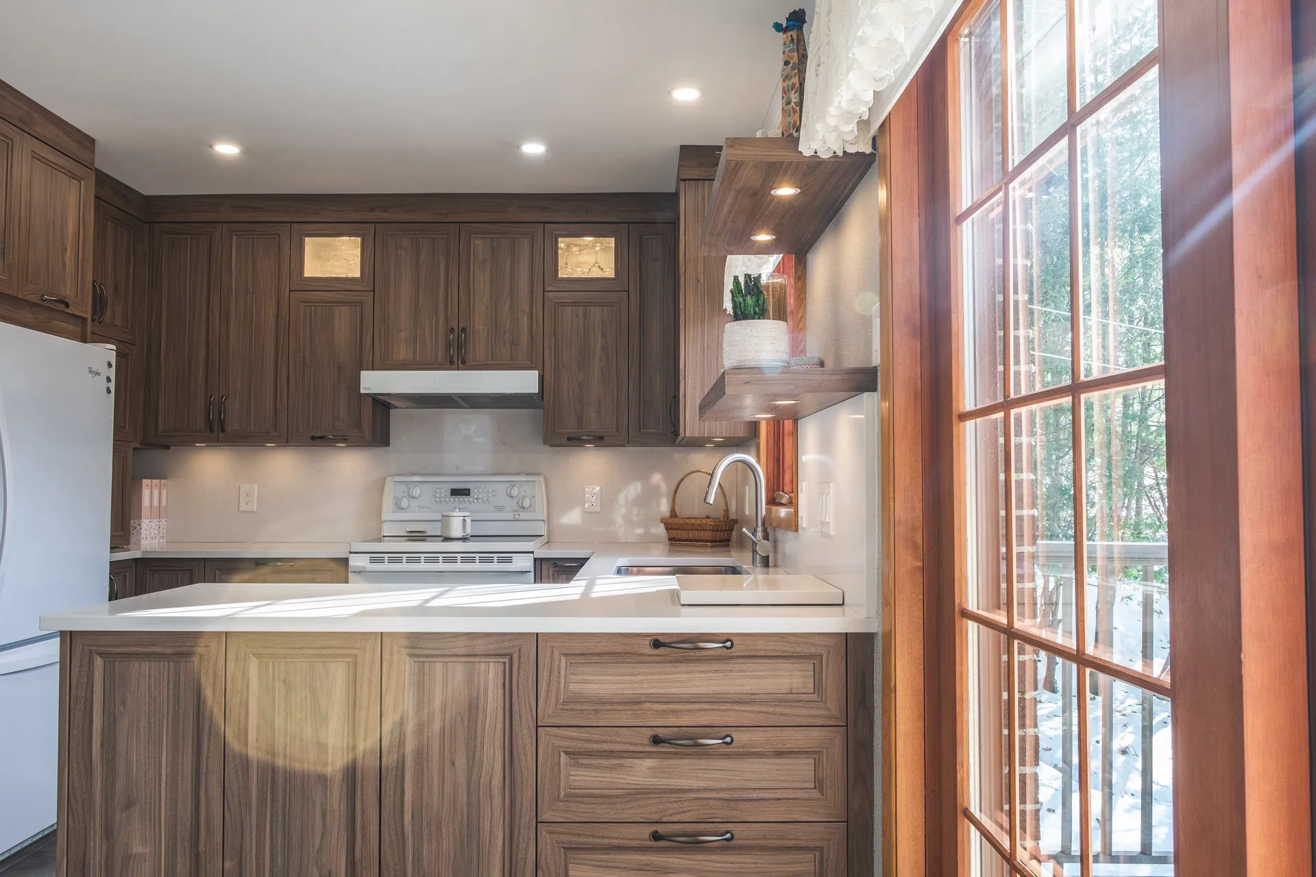 Nadon Kitchen Rosemère: dark walnut cabinets, white countertop, island, taupe backsplash, wood windows, recessed lighting