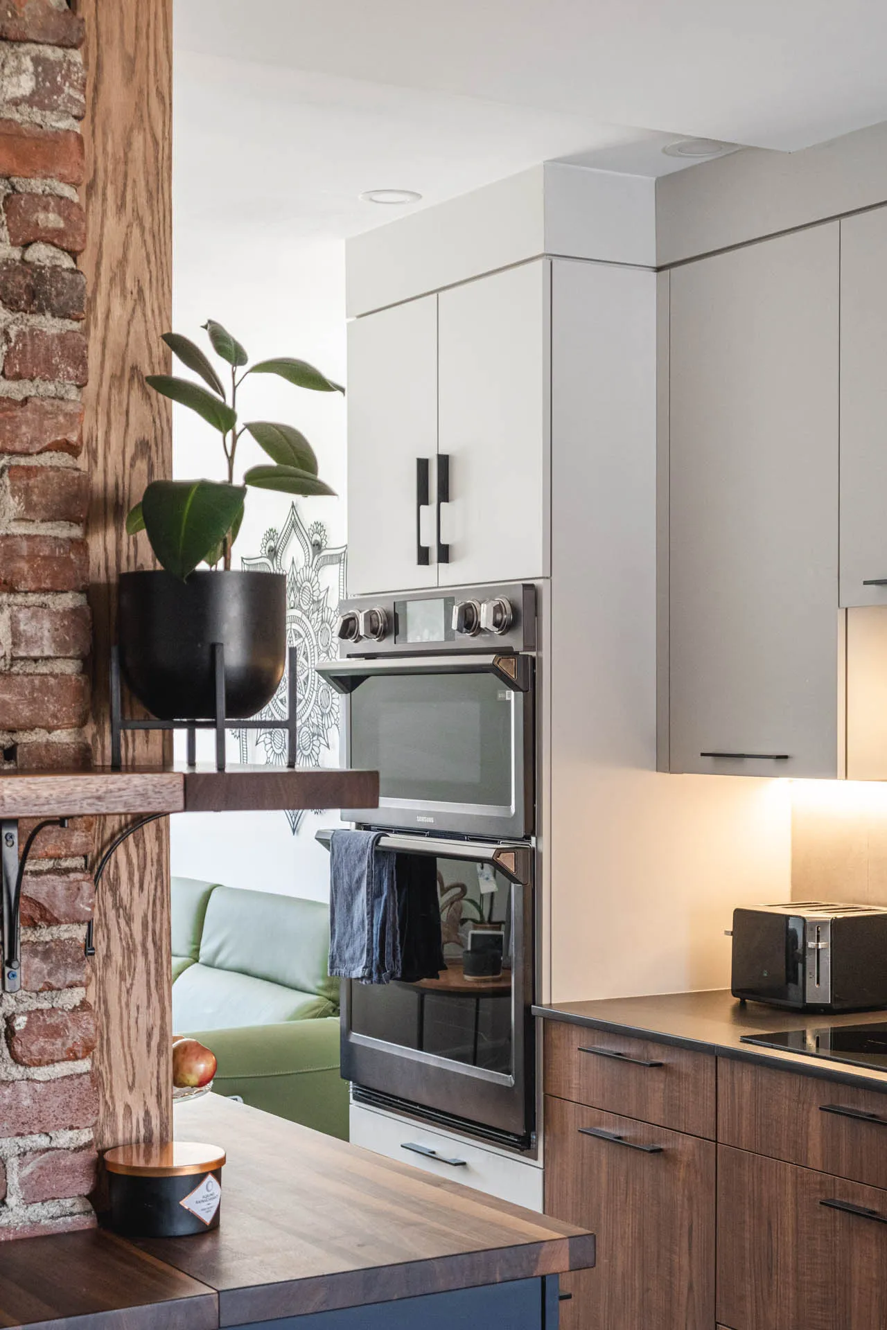Florez kitchen by Menuitech: white and wood cabinets, wood countertop, built-in oven, geometric backsplash, recessed lighting.