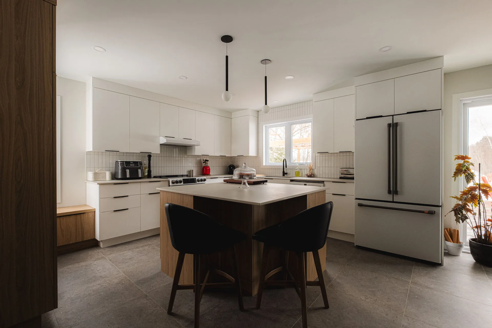Modern Robitaille kitchen Épiphanie: white cabinets, wood island, white countertops, tile backsplash, stainless steel appliances