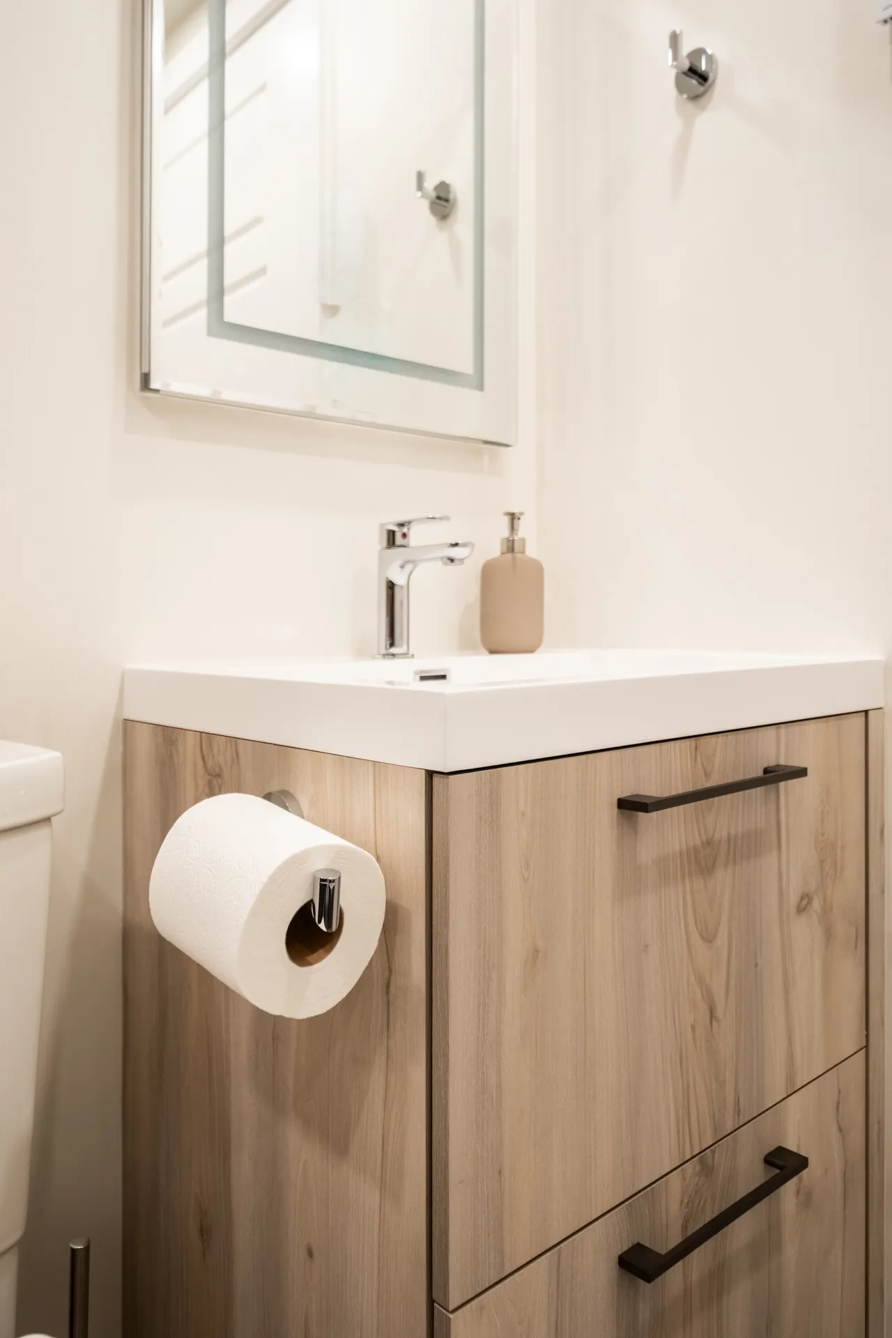 Vanité salle de bain bois clair Menuitech avec comptoir blanc, miroir encadré et accessoires chrome
