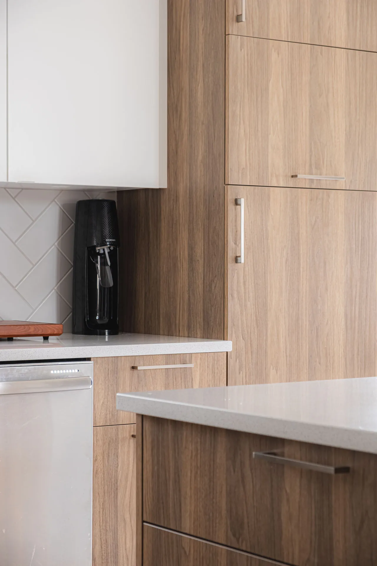 Gagné-Lalonde kitchen: light oak cabinets, white countertops, white tile backsplash, island, integrated appliances
