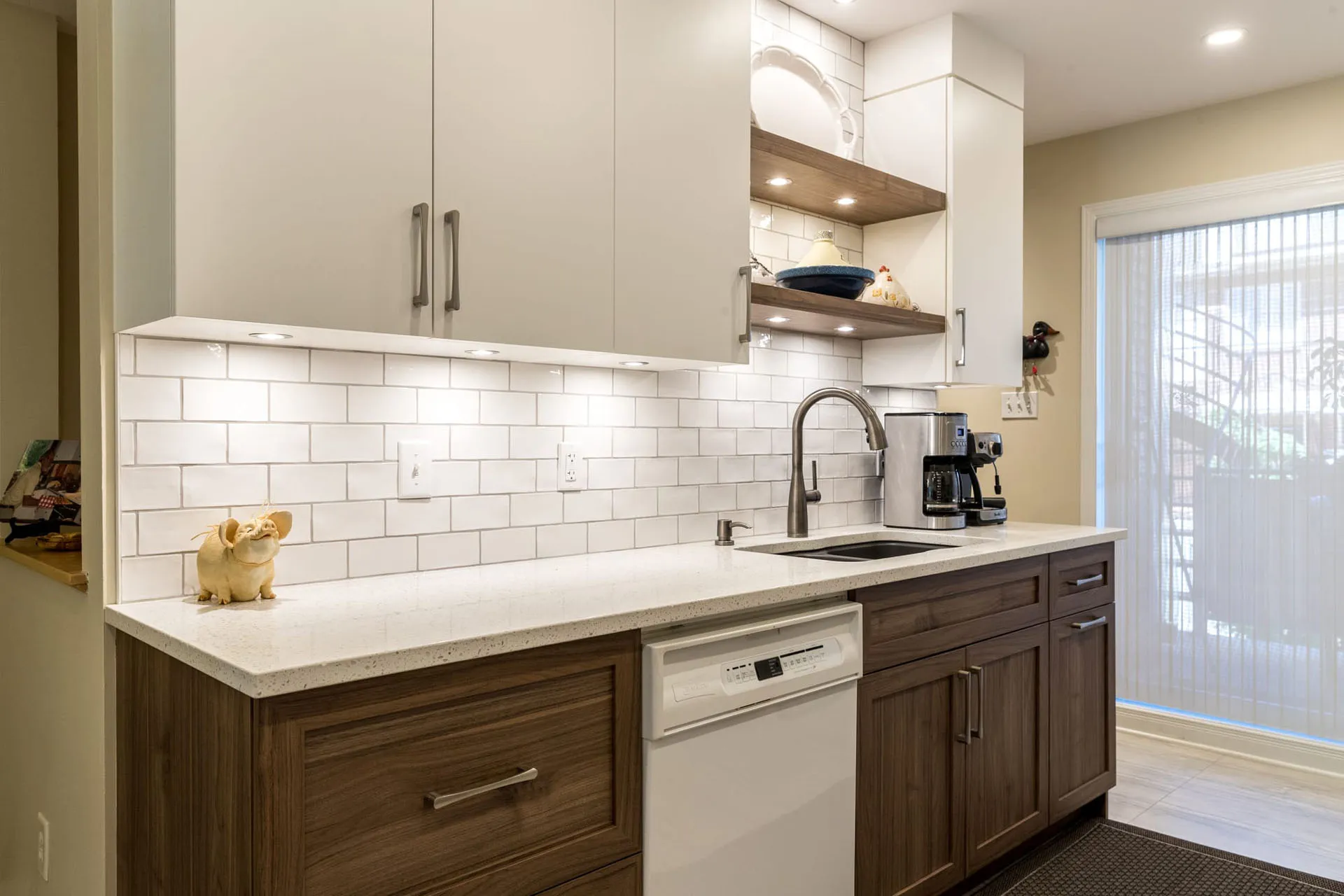 Modern Mathieu kitchen: white and walnut cabinets, off-white countertop, subway tile backsplash, storage island.