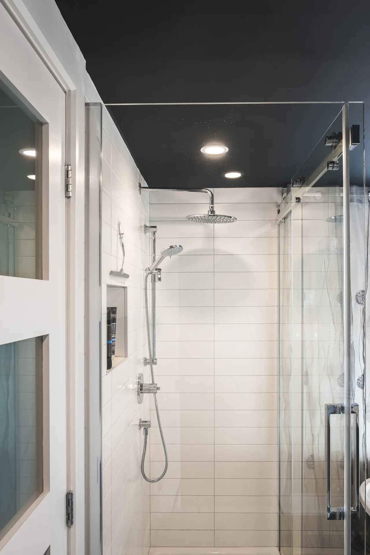 Modern Menuitech bathroom Laval: glass shower enclosure, white horizontal tiles, black ceiling, recessed lighting fixtures