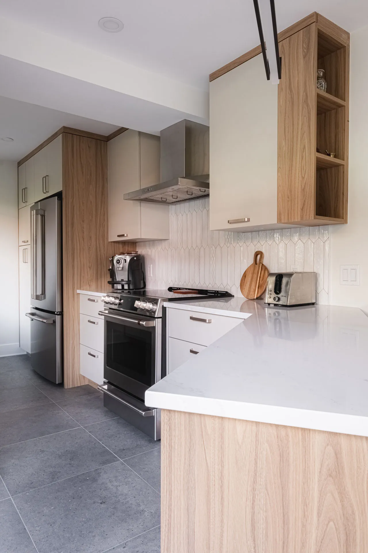 Modern Leduc-Desjardins kitchen: white and natural wood cabinets, white countertop, chevron backsplash, island, stainless steel appliances.