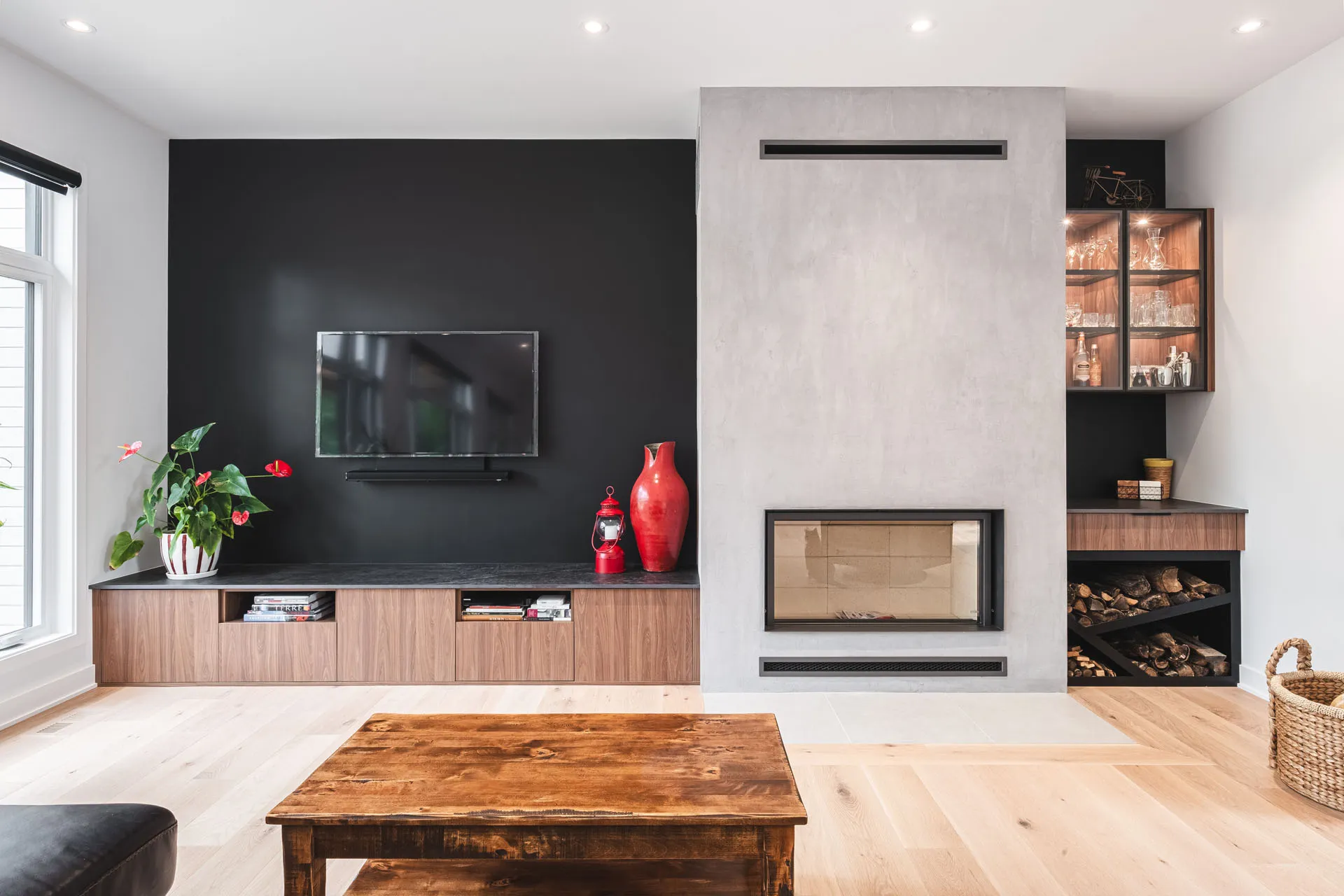 Modern living room with built-in fireplace, walnut TV unit, black wall, black countertop and wood storage