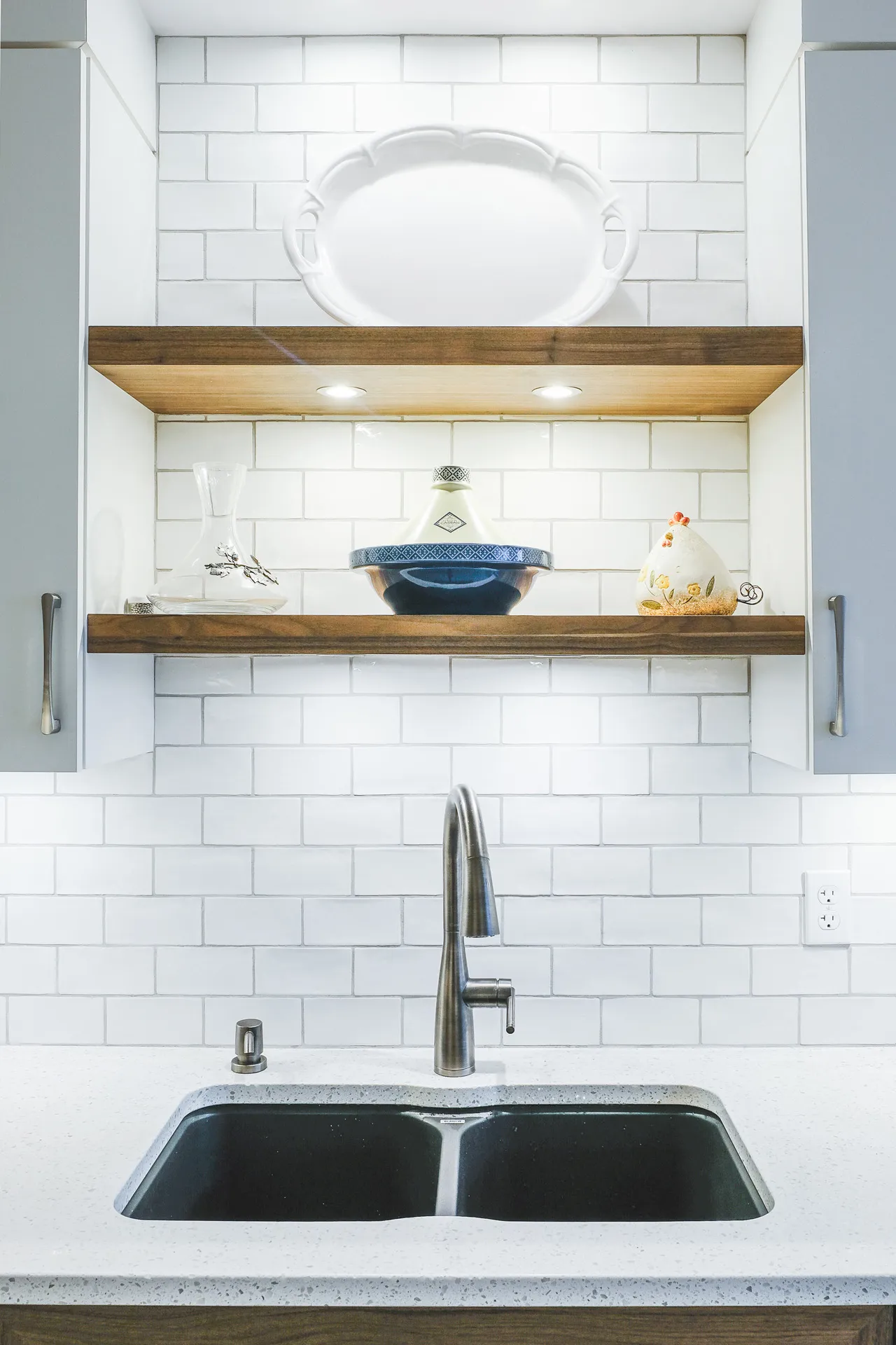 Mathieu kitchen Montreal: white cabinets, grey countertop, white subway backsplash, wooden shelves, black double sink