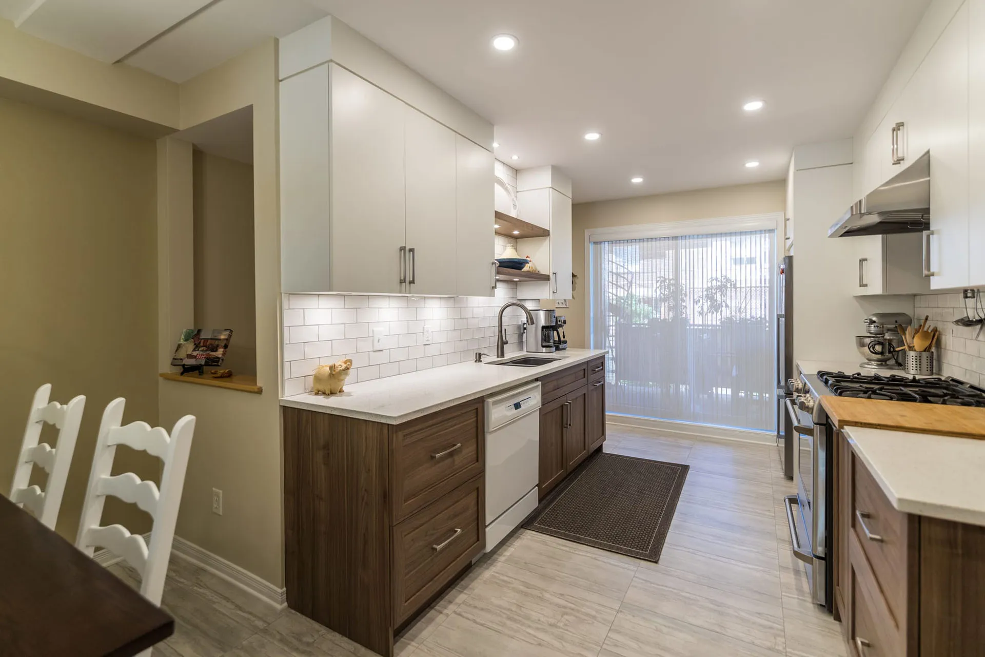 Mathieu kitchen Montreal: white and brown cabinets, white countertop, subway tile backsplash, central island, recessed lighting