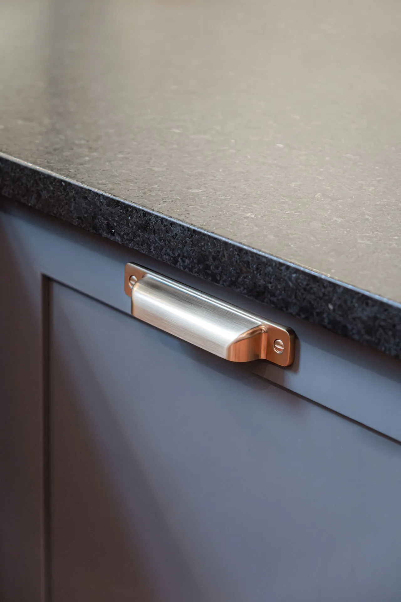 Copper and steel handle on grey cabinet with black granite countertop, Stephan project Montreal Menuitech