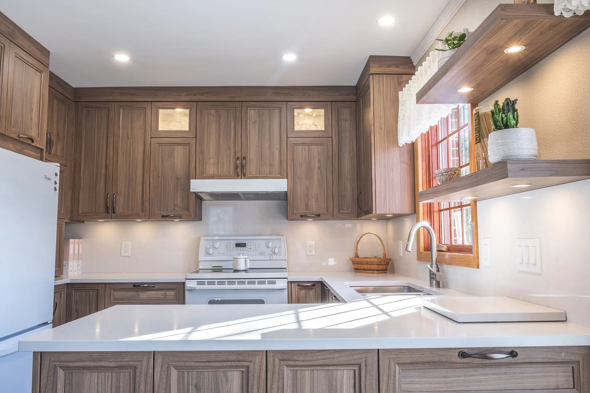 Nadon kitchen Rosemère: walnut cabinets, white countertop, island, beige backsplash, recessed lighting