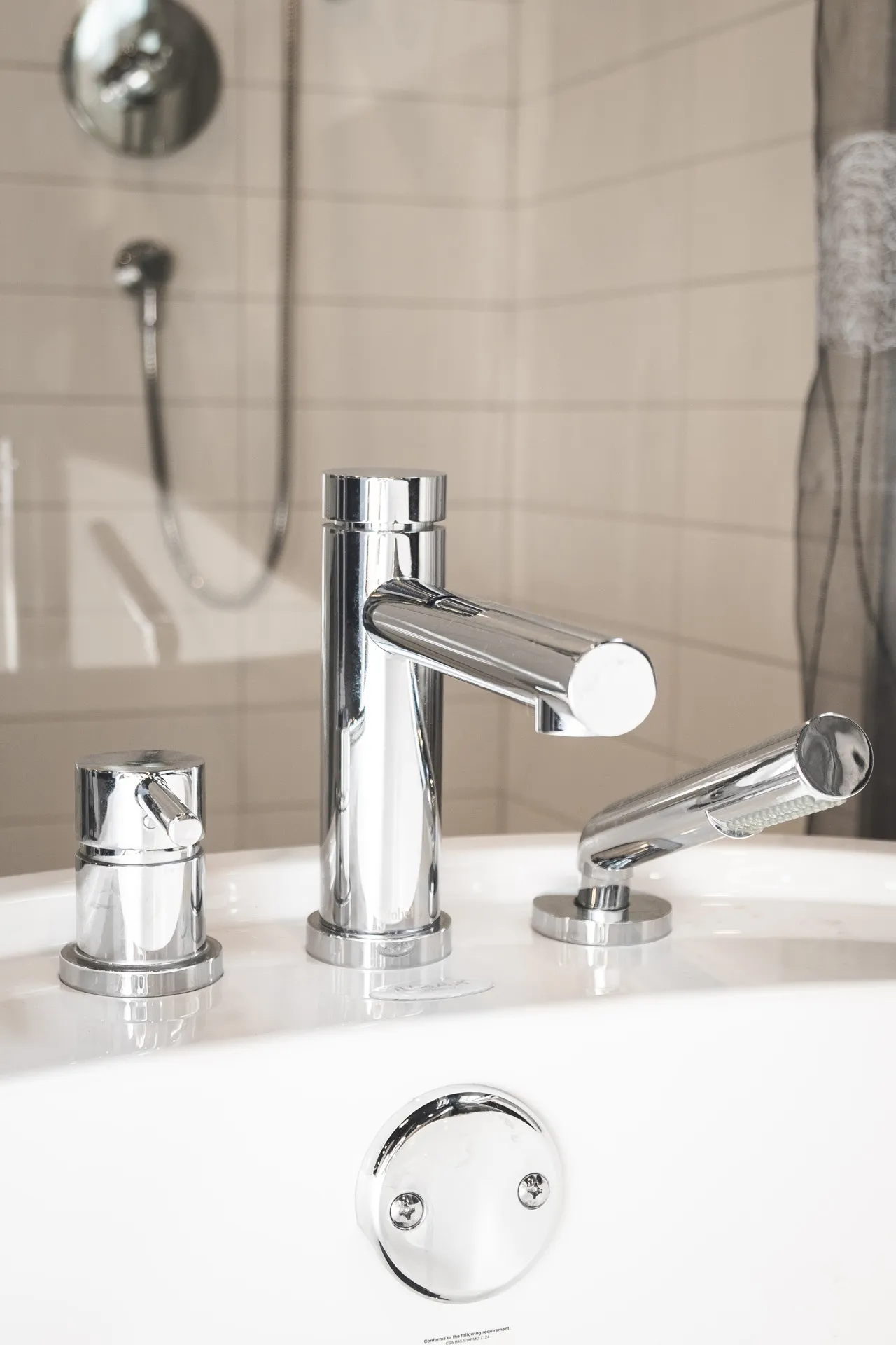 Modern chrome faucet on white countertop, beige tile backsplash, Menuitech Pagé bathroom Laval