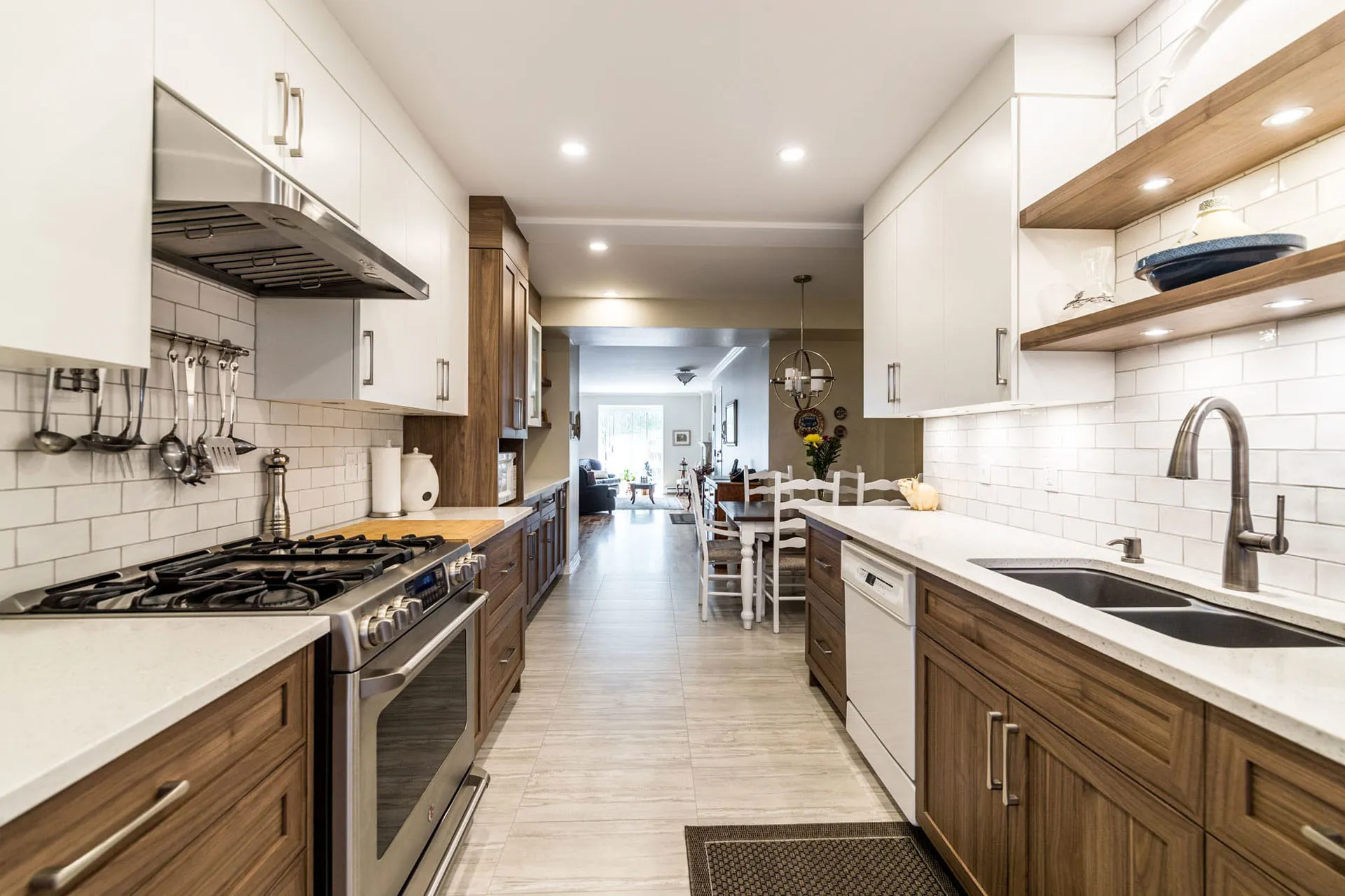 Mathieu kitchen Montreal: white and wood cabinets, white countertops, island, subway backsplash, stainless steel appliances