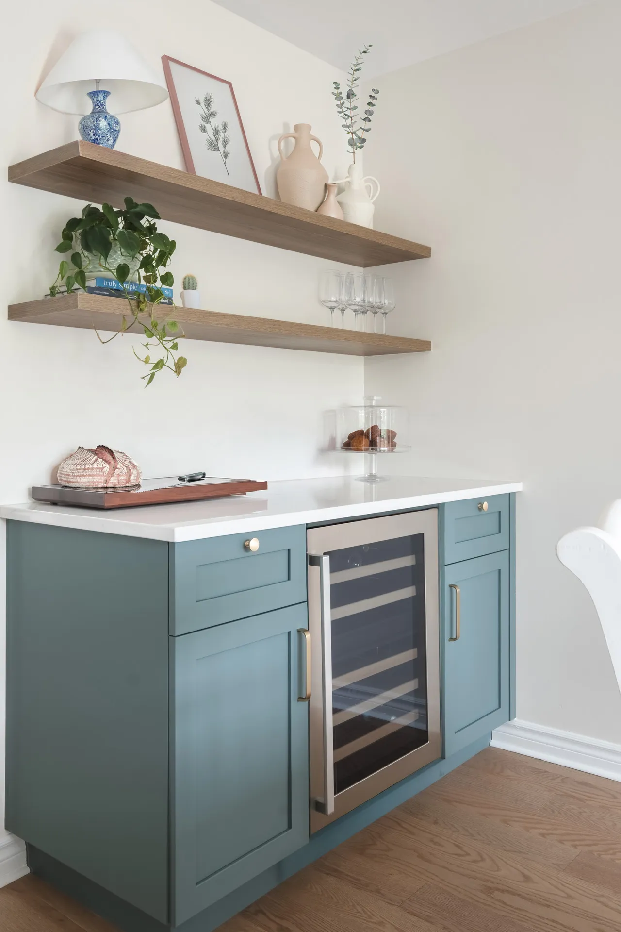 Modern Mascouche kitchen: blue-gray cabinets, white countertop, island with built-in wine cooler, wooden shelves, contemporary style