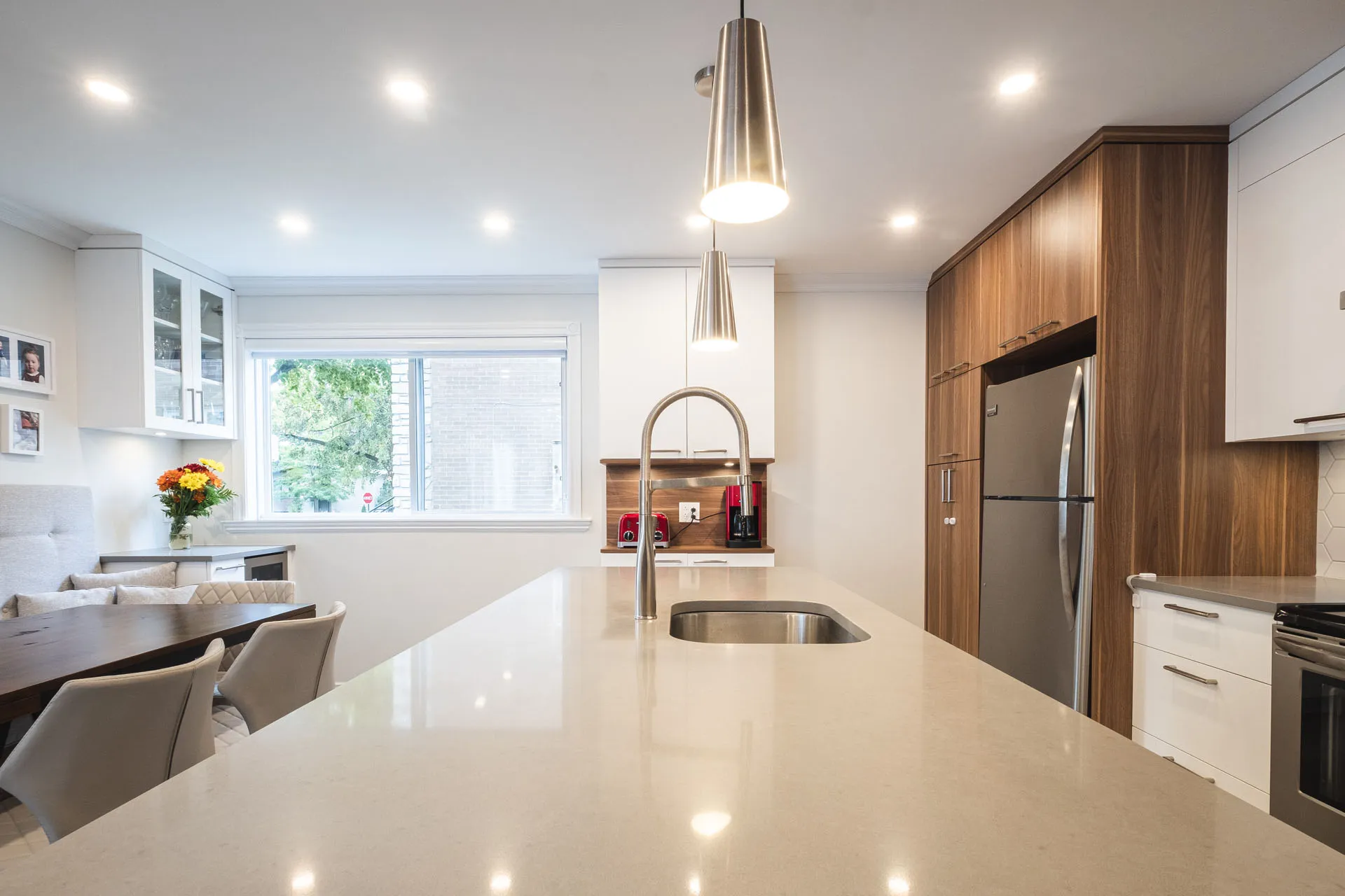 Tardif Kitchen Montreal: walnut cabinets, white quartz countertop, center island, stainless steel appliances, pendant lights.