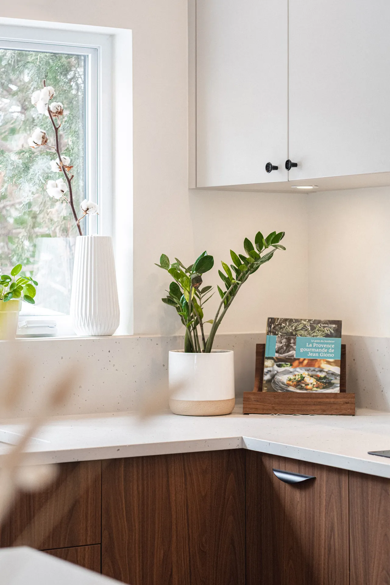 Cuisine moderne avec armoires noyer foncé, comptoir blanc clair, dosseret gris clair et fenêtre naturelle - Projet Sudan Montréal