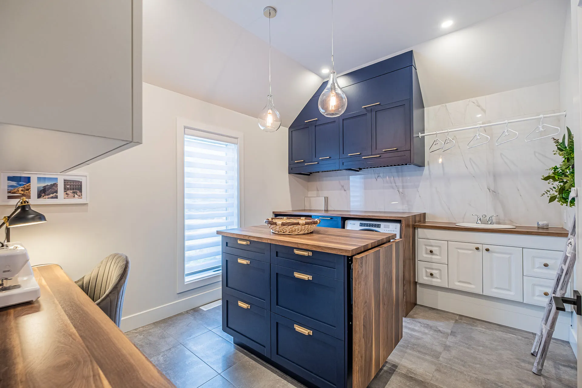 Simard kitchen: navy and white cabinets, wood island, white marble backsplash, glass pendant lights, contemporary style