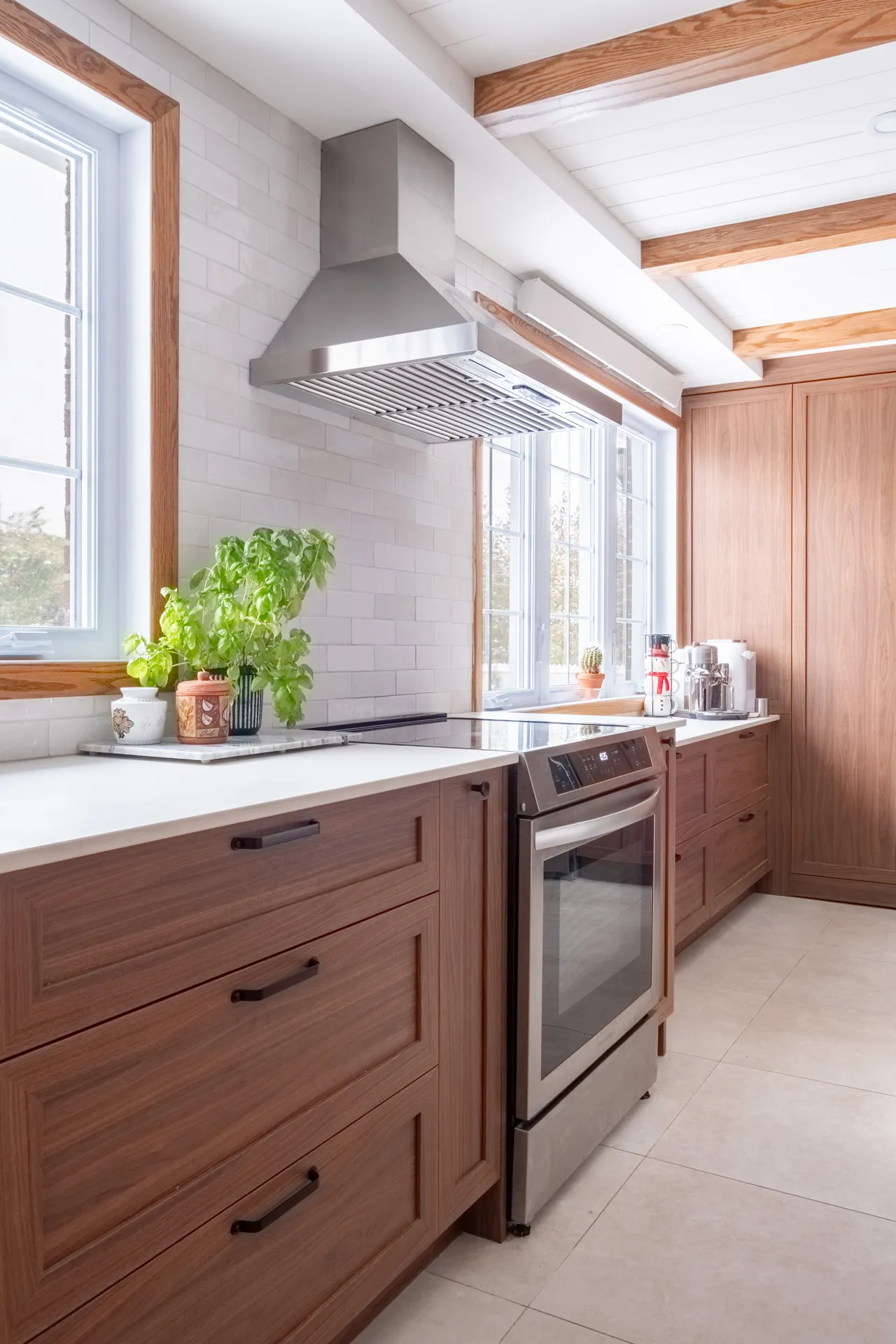 Lemay kitchen: walnut wood cabinets, white countertop, central island, white subway tile backsplash, stainless steel hood