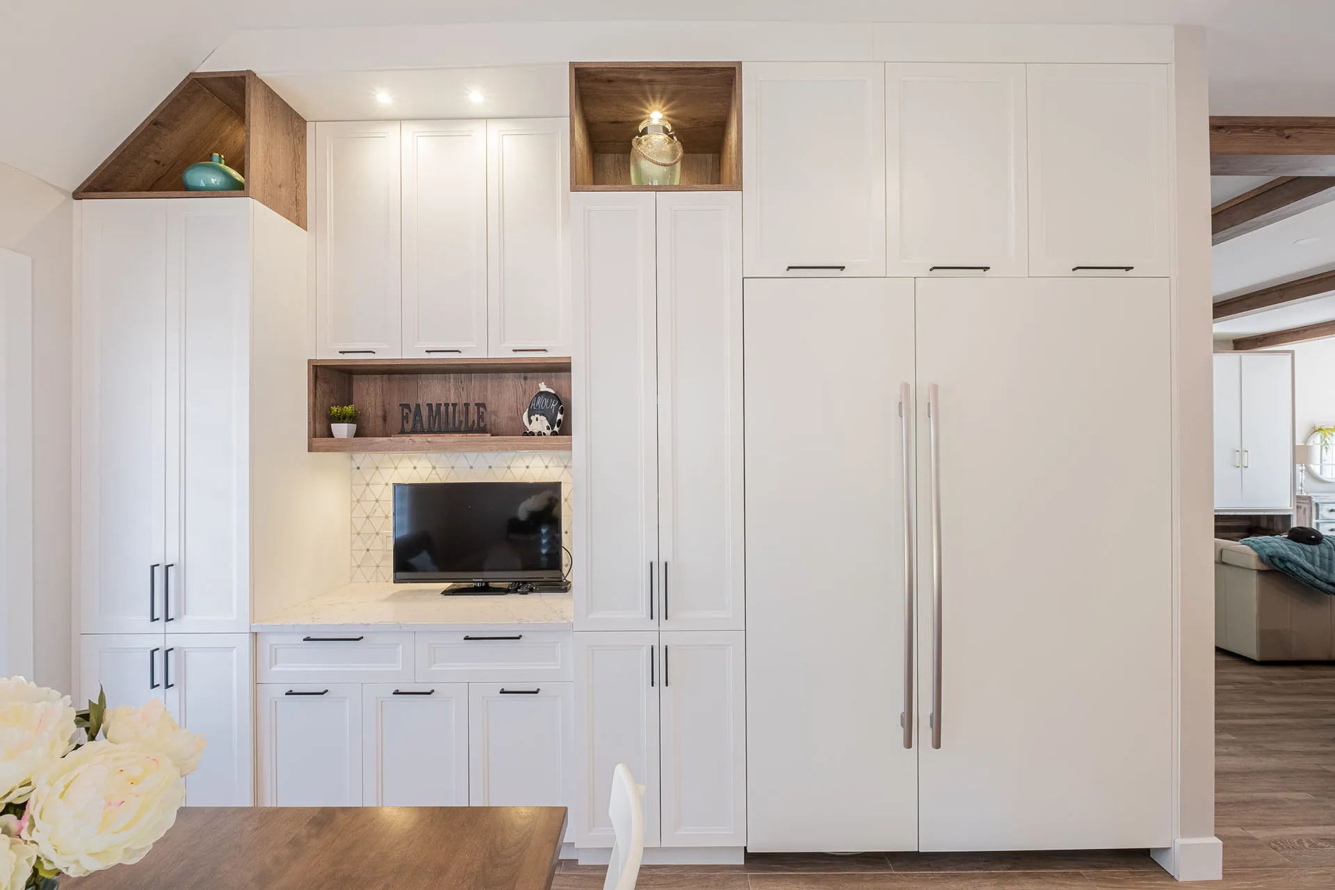 Modern white kitchen with custom cabinets, wood countertop, geometric backsplash and integrated TV cabinet - Simard Project