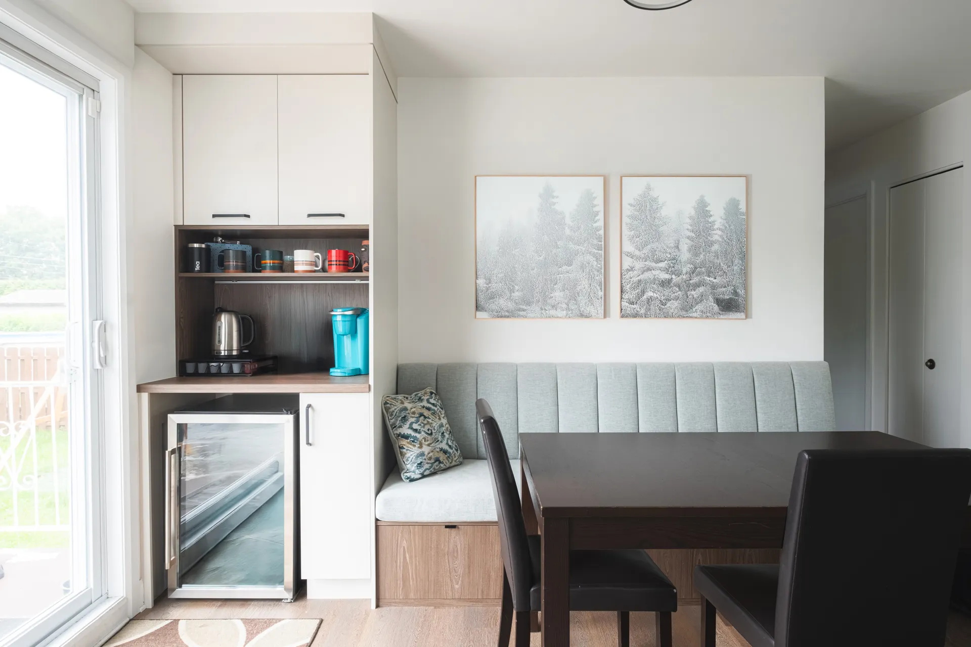 White and wood kitchen with natural countertop, built-in mini fridge and grey upholstered banquette