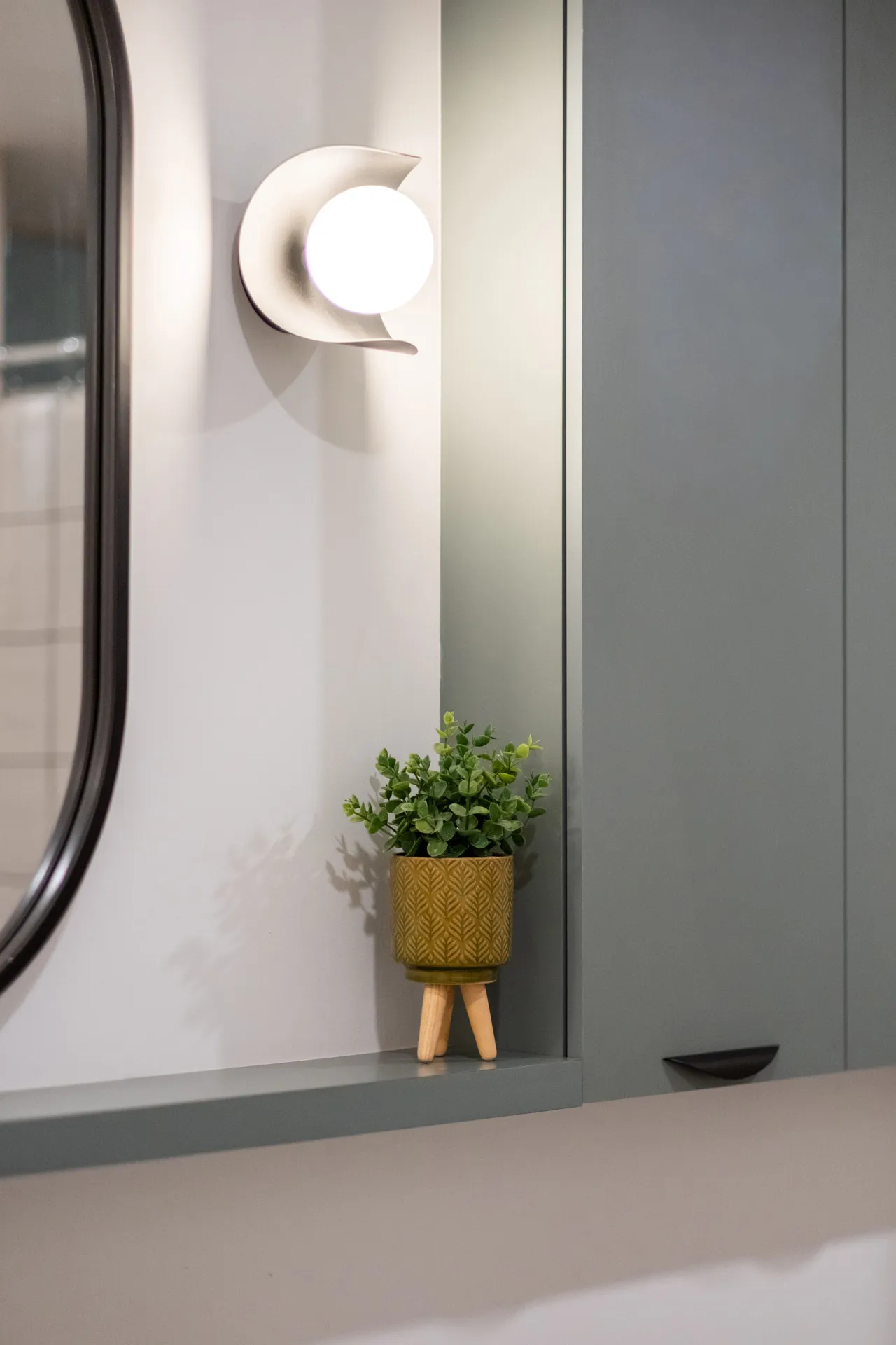 Salle de bain moderne Menuitech projet Fabiola : armoires grises, comptoir gris clair, miroir rond, applique murale blanche