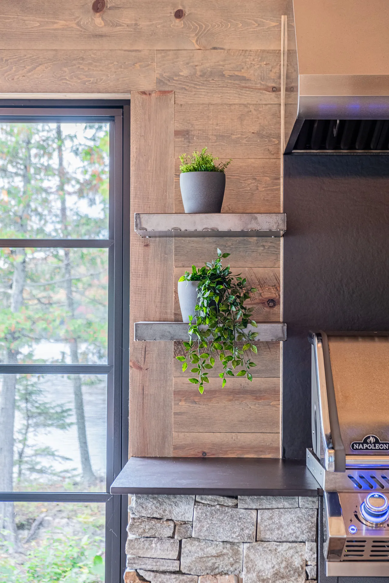Modern kitchen with light wood cabinets, gray countertop, wood backsplash, floating shelves and panoramic window