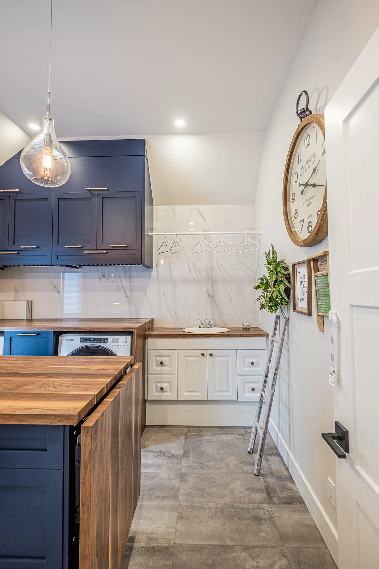 Renovated kitchen with navy and white cabinetry, wood island, marble countertops, tile backsplash and Menuitech cabinets