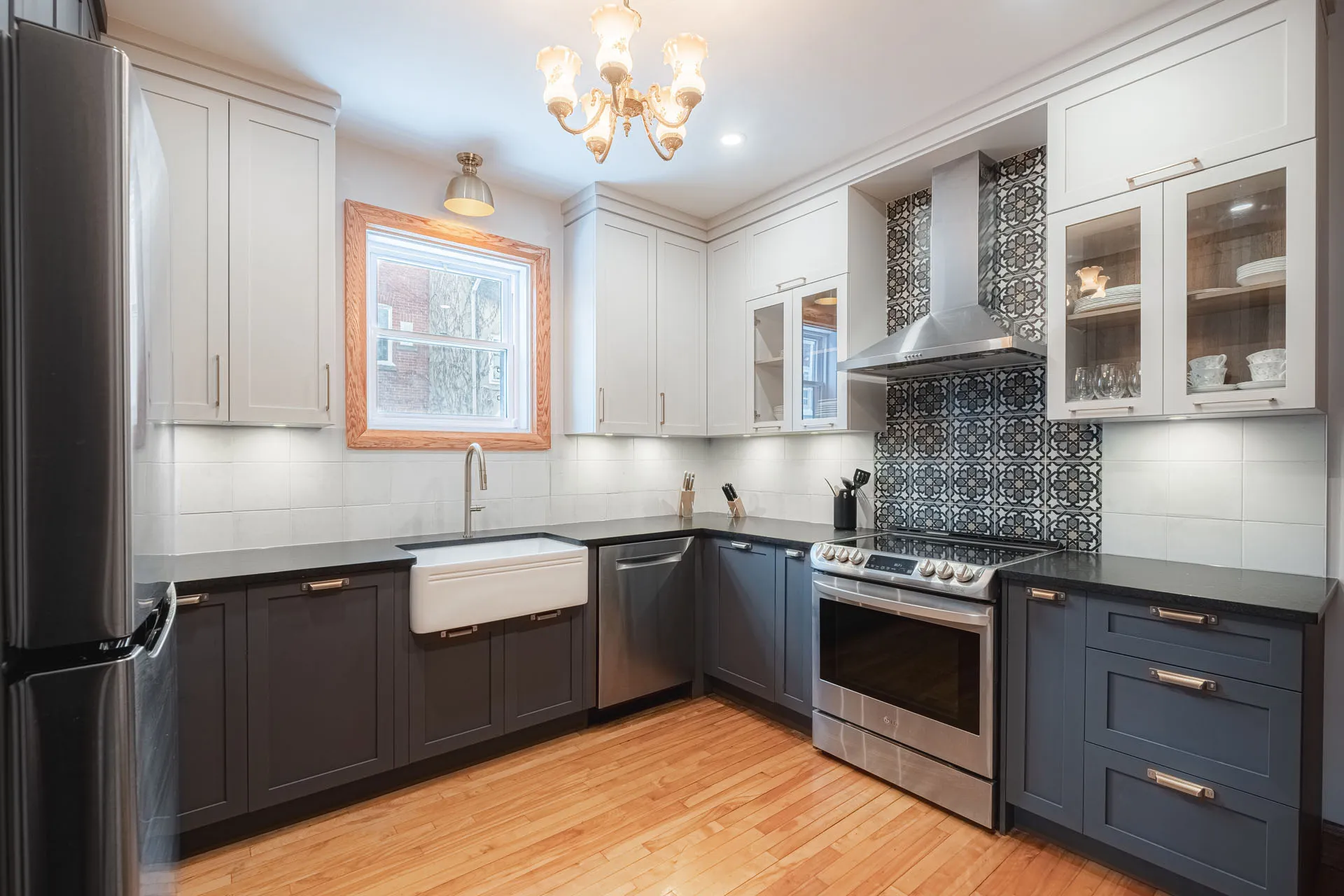 Stephan Kitchen Montreal: white and grey cabinets, black countertops, geometric backsplash, stainless steel appliances