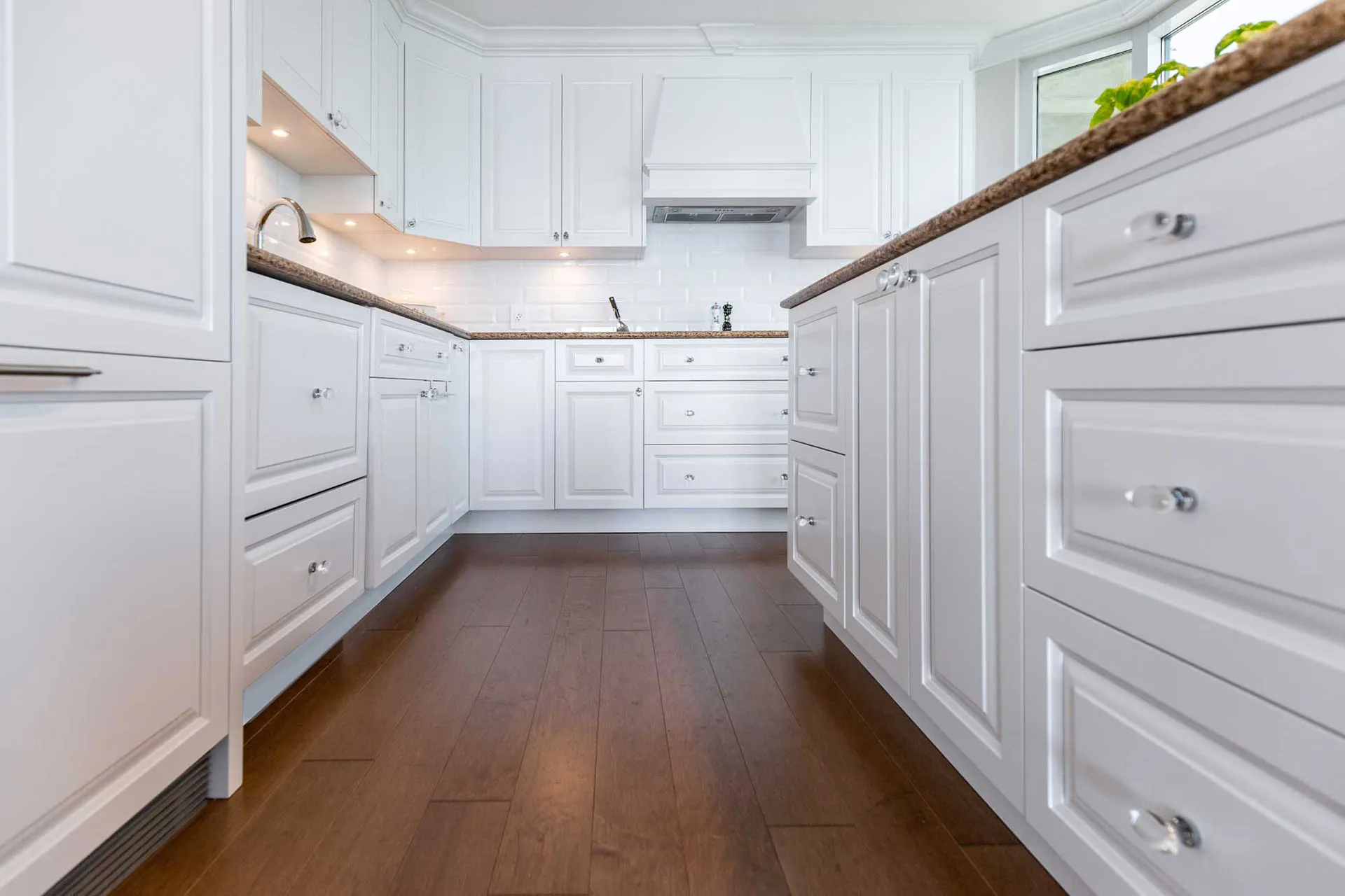 White Menuitech kitchen with wood countertop, shaker cabinets, white backsplash, center island and recessed lighting