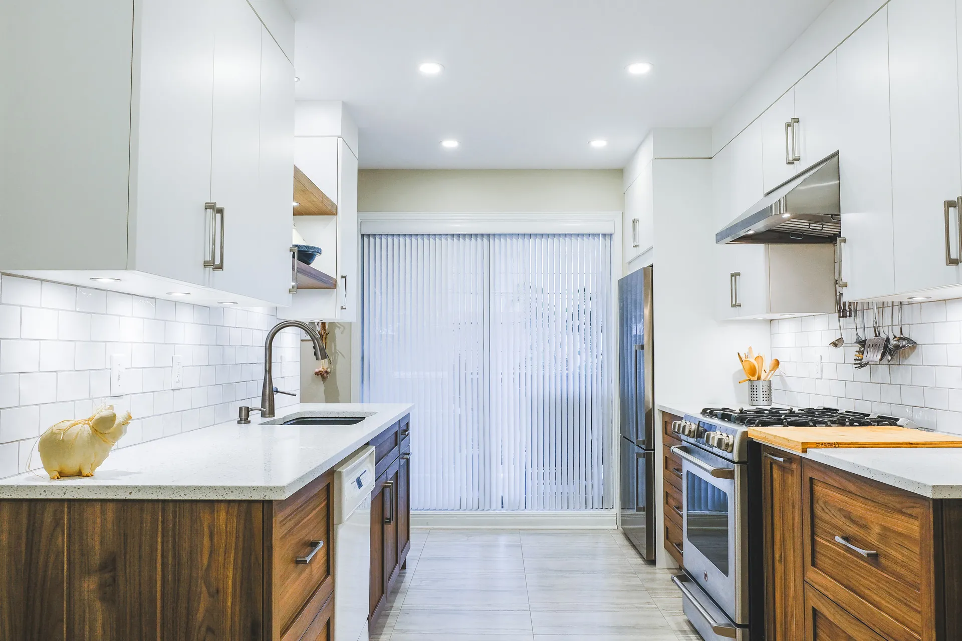 Mathieu kitchen Montreal: white and wood cabinets, white countertop, subway backsplash, island, gas range, LED lighting