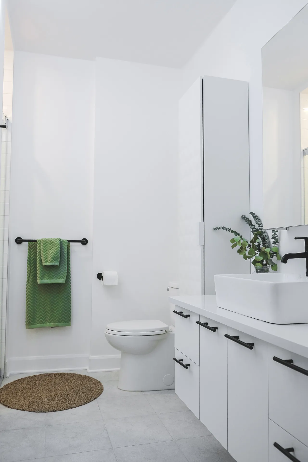 Modern bathroom with white cabinetry, white countertop, square vessel sink and matte black fixtures