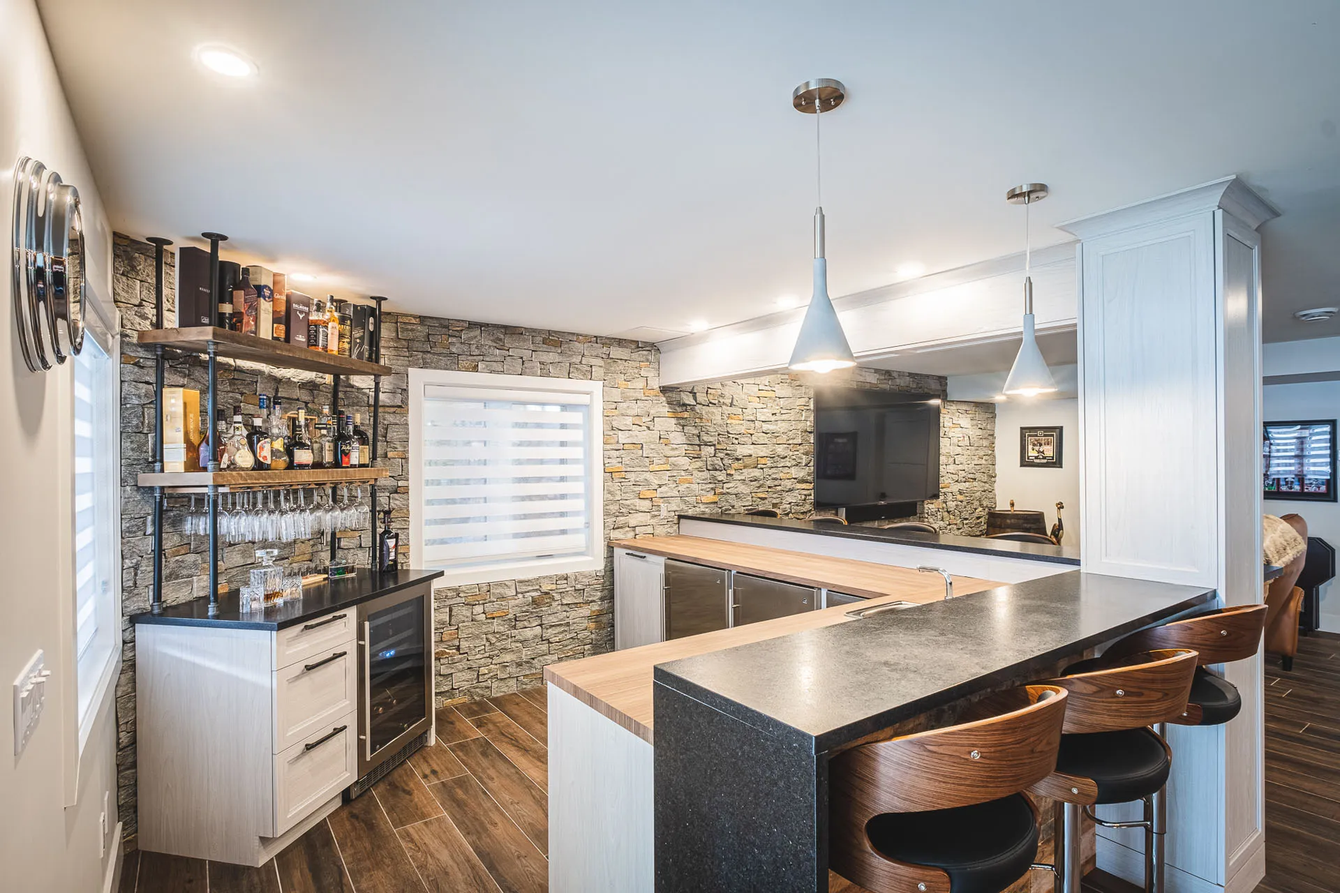 Modern Simard kitchen: white cabinets, black countertop, wood island, stone backsplash, pendant lights
