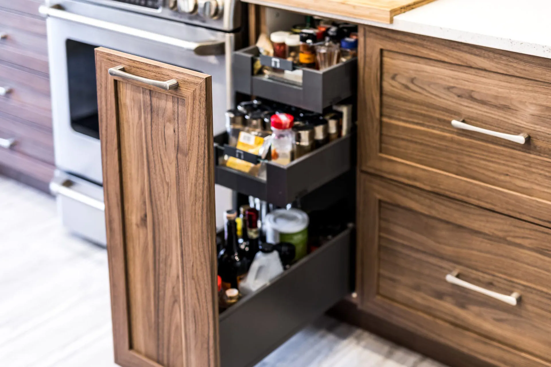 Mathieu kitchen Montreal: walnut cabinets with black pull-out drawers, wood countertop, organized storage space