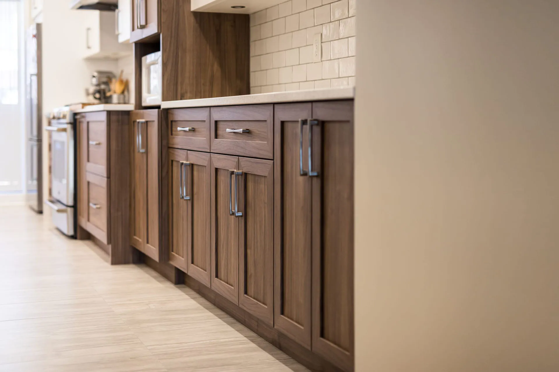 Mathieu kitchen Montreal: walnut shaker cabinets, white countertop, subway backsplash, chrome hardware