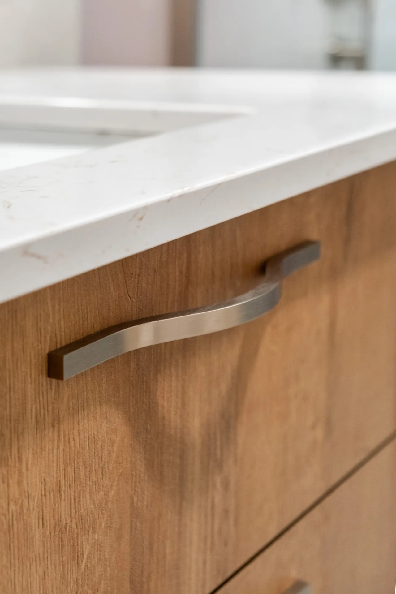Armoires de salle de bain en bois naturel avec comptoir blanc et poignées en acier inoxydable, projet Forand Laval
