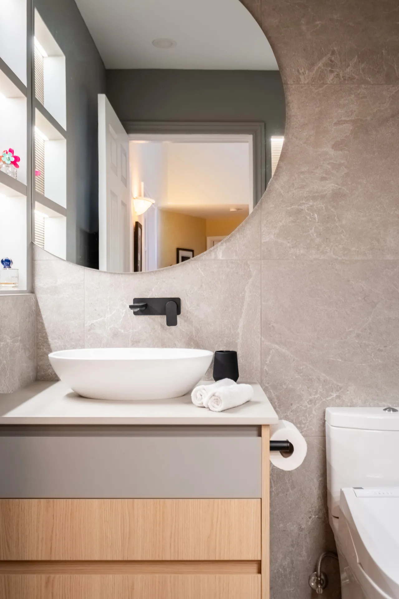 Salle de bain moderne Rosemère : armoires Menuitech gris et bois, vasque blanche ronde, miroir courbe, robinetterie noire