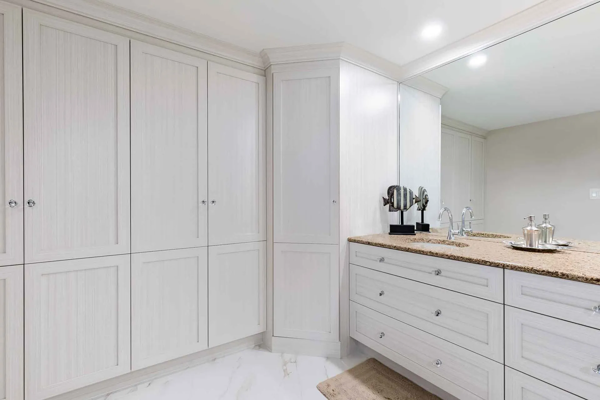 McDuff bathroom Repentigny: white cabinetry, beige granite countertop, large mirror, double sink vanity