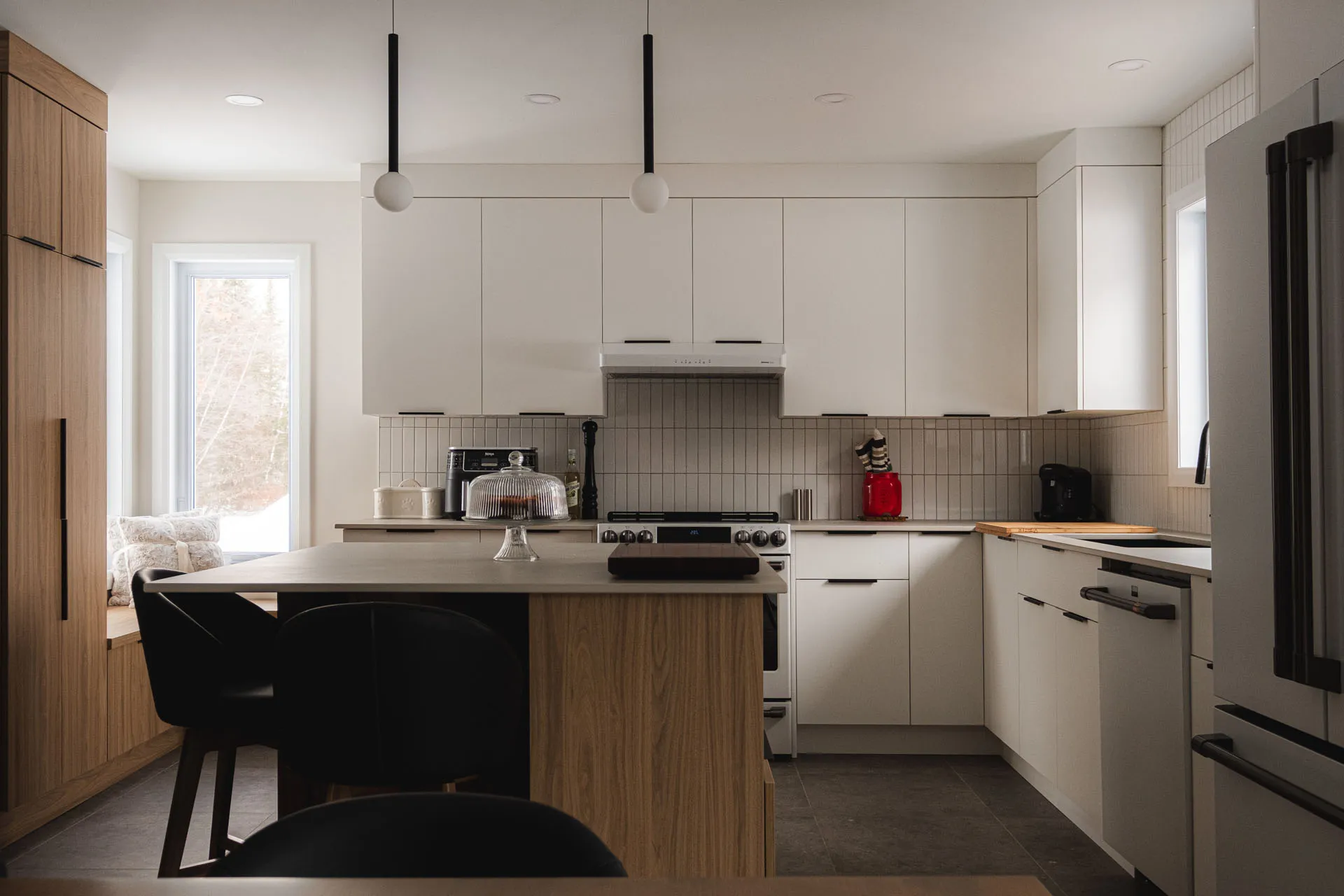 Modern Menuitech kitchen with white cabinets, wooden island, grey countertops, tile backsplash, black pendant lights