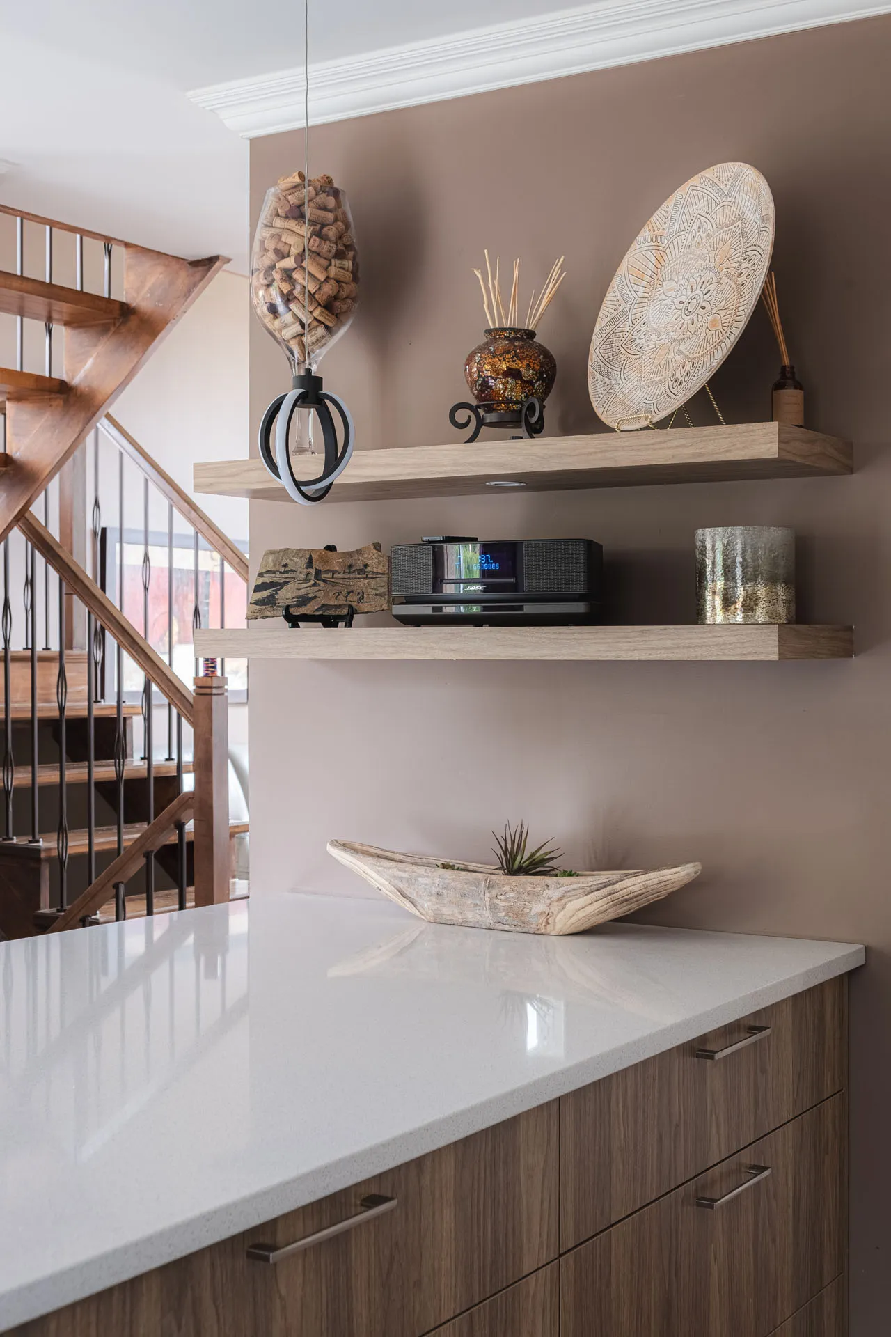 Modern Menuitech kitchen with natural wood cabinets, white glossy countertop, floating shelves and wooden staircase