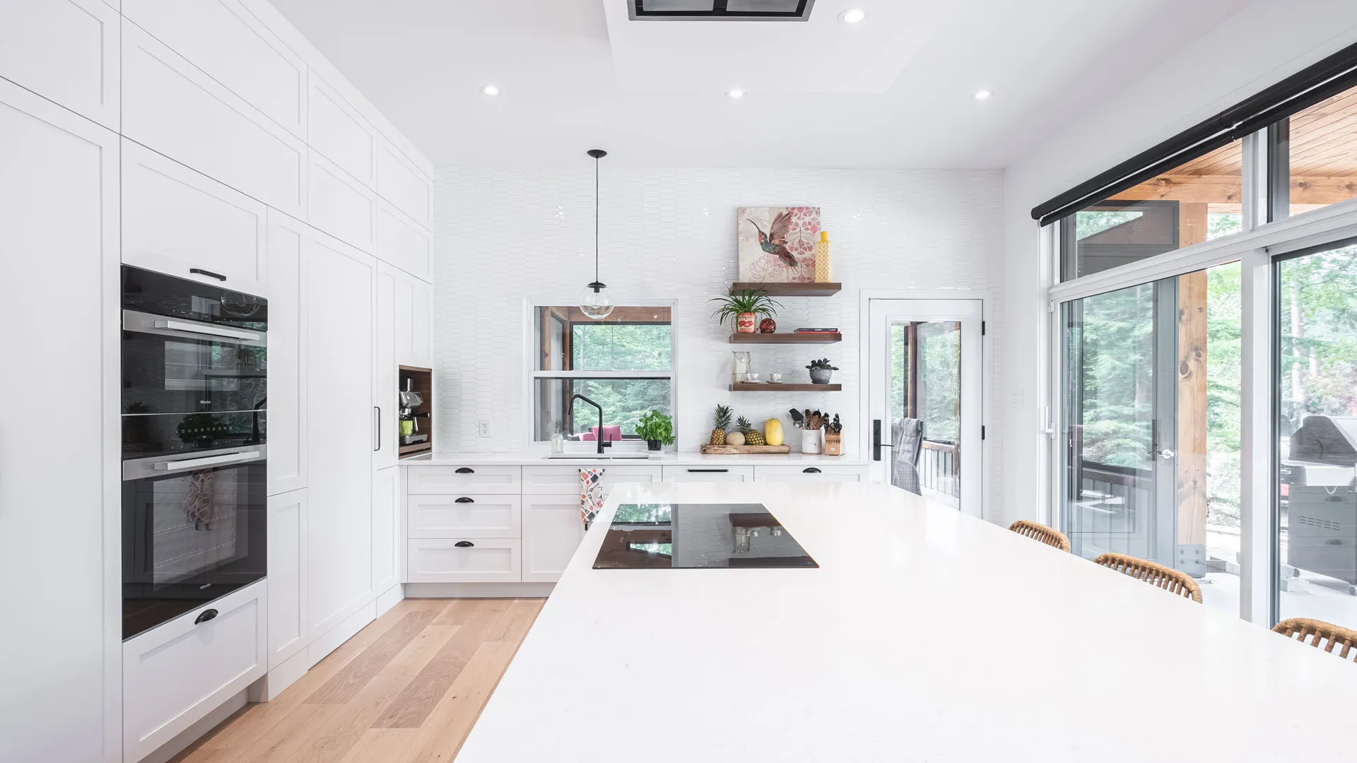 Modern white Diard kitchen with island, grey countertops, white brick backsplash and large glass doors
