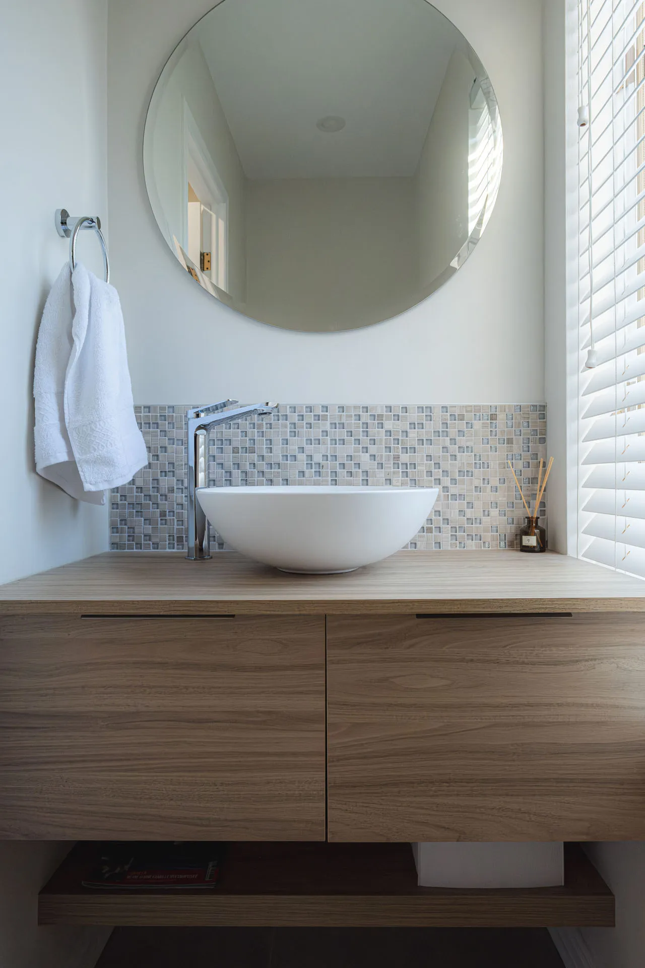 Salle de bain moderne Garreaud : vanité bois, comptoir gris, dosseret carreaux bleus, miroir rond, lavabo blanc
