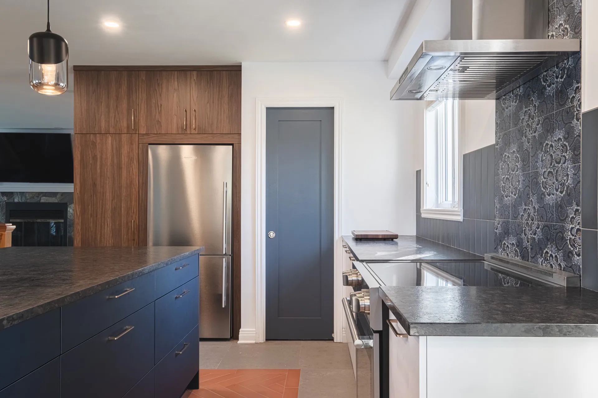 Denis Kitchen Montreal: navy blue and walnut cabinets, grey quartz countertop, island, damask backsplash, stainless hood