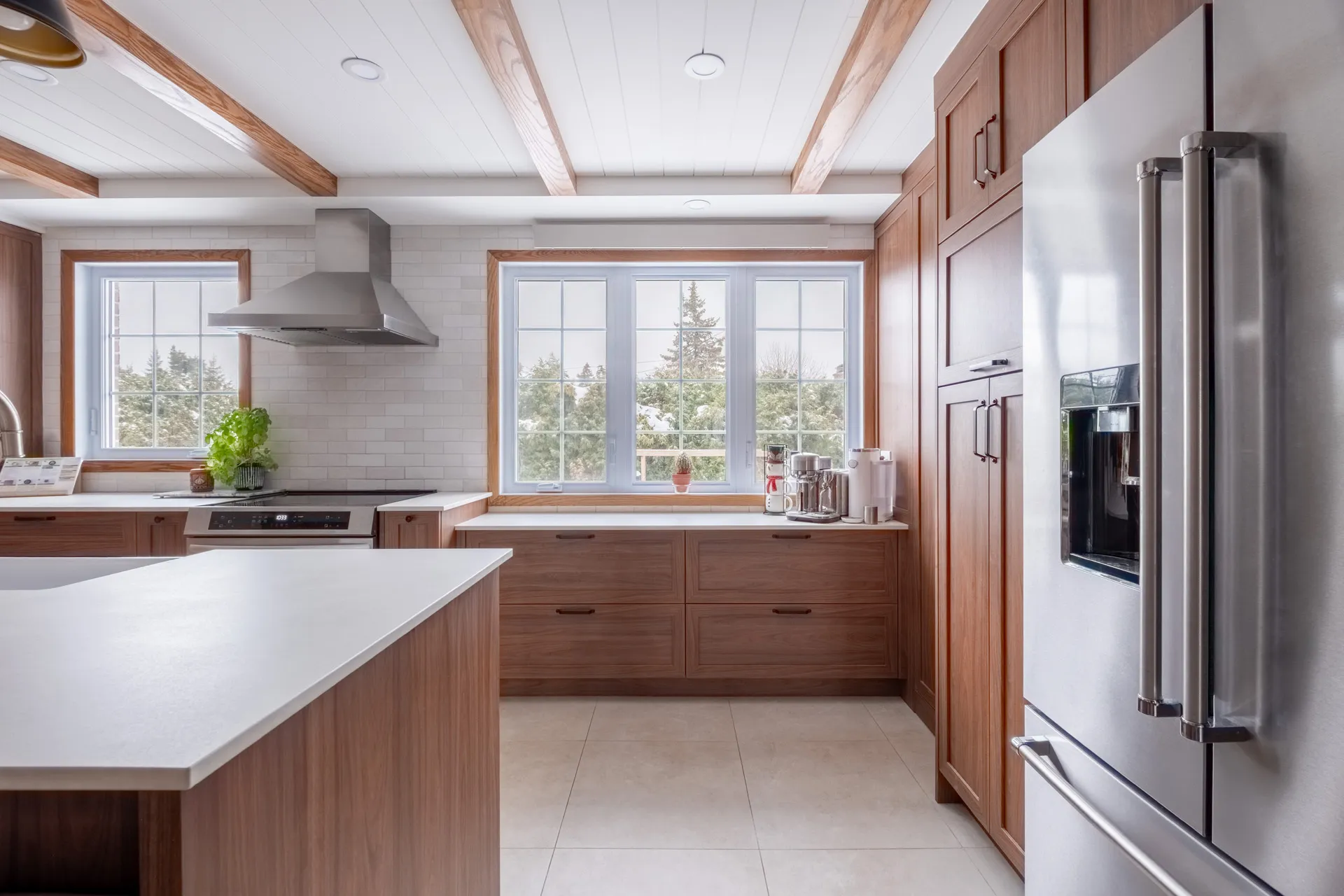 Lemay kitchen Laval: walnut cabinets, white countertops, central island, white subway backsplash, wood windows