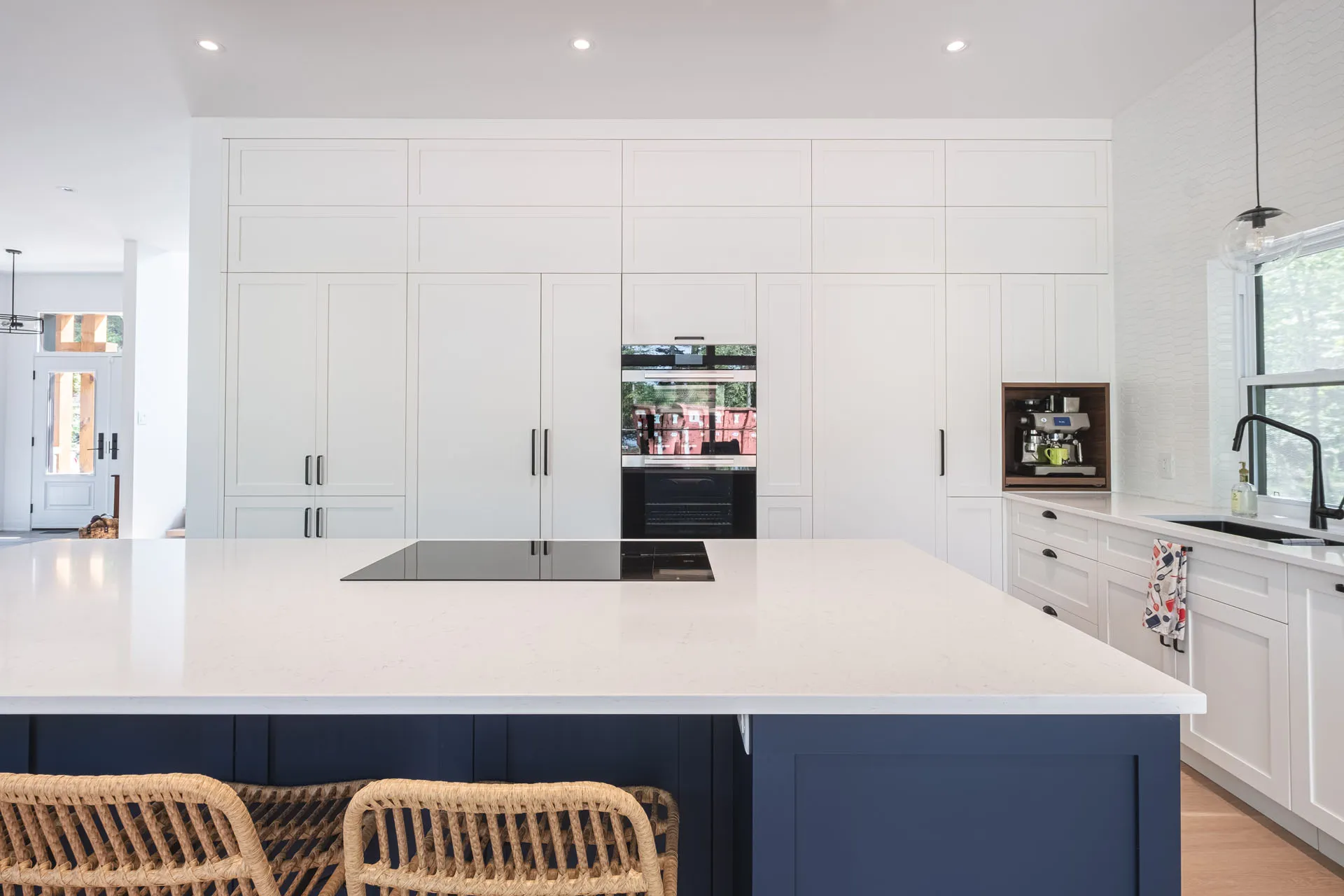 Menuitech white and navy blue kitchen with island, white countertops, custom cabinets and tiled backsplash